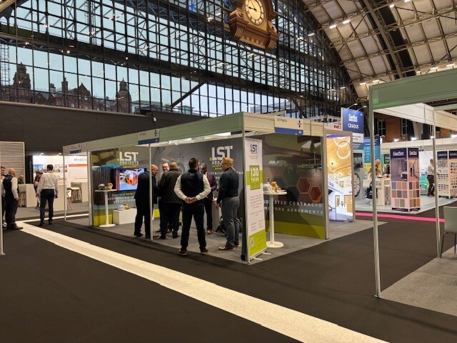 LST Projects exhibition stand with visitors at a healthcare industry event.